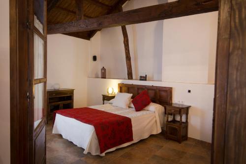 a bedroom with a bed with a red blanket at Casa Rural Casona la Beltraneja in Belmonte