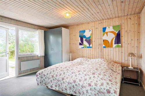 a bedroom with a bed in a room with wooden walls at 8007-Knebel-Soren-Jeppesens-Vej-5 in Knebel