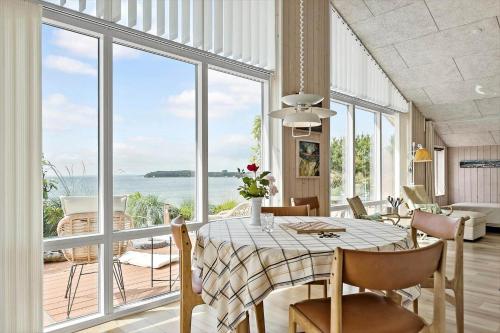 a dining room with a table and a view of the ocean at 8119-Ronde-Strandvejen-136 in Rønde