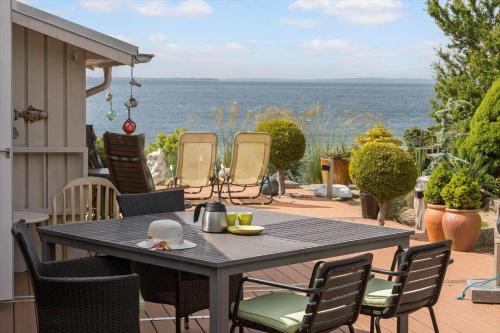 a table on a patio with a view of the ocean at 8119-Ronde-Strandvejen-136 in Rønde