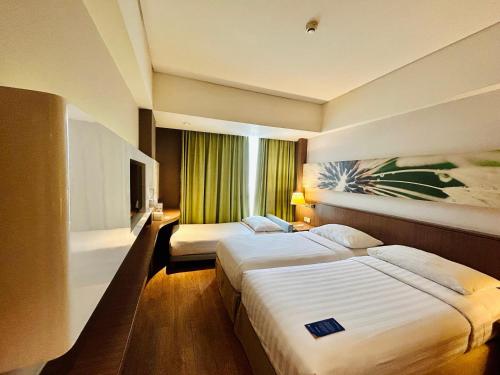 a hotel room with two beds and a window at Soll Marina Hotel Serpong in Serpong