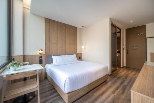 a bedroom with a white bed and a bathroom at SHAN Villas Sukhumvit in Bangkok