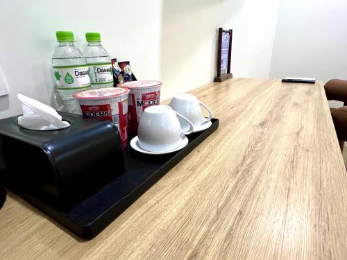 a table with cups and plates and drinks on it at Vuon Xanh Hotel & Cafe in Xóm Mỹ Xuân