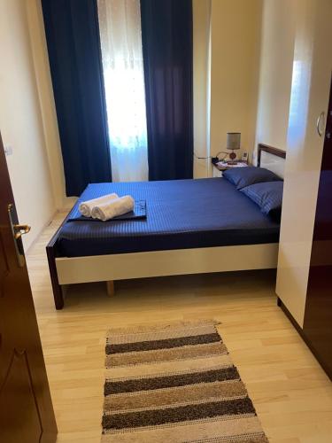a bedroom with a bed with blue sheets and a window at Domus Komanesse - Guest Houses in Koman