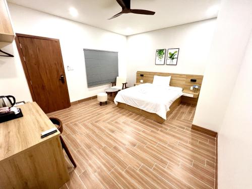 a bedroom with a bed and a wooden floor at Vuon Xanh Hotel & Cafe in Xóm Mỹ Xuân