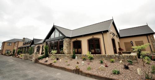 a building with a lot of plants in front of it at Mulroy Woods Hotel in Milford