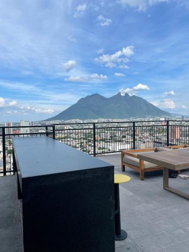a table and benches on a balcony with a mountain at Depa en el corazón de Monterrey in Monterrey