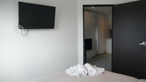 a room with a bed with a television on the wall at Tranquil Tide 1 BR T1-605 in Ban Klang
