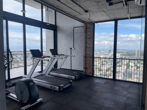 a gym with a treadmill and a laptop in a room with windows at Depa en el corazón de Monterrey in Monterrey