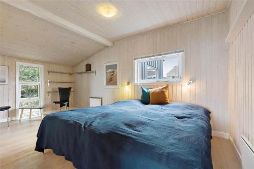 a bedroom with a blue bed in a room at 8124-Ronde-Rytterparken-33 in Rønde