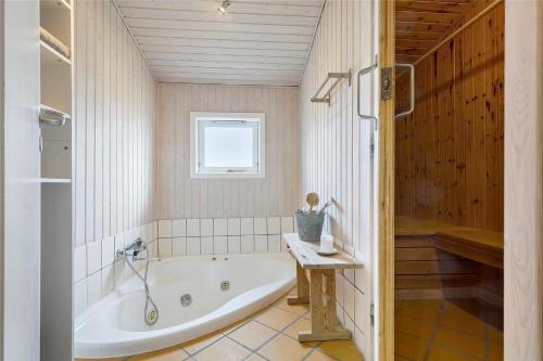 a bathroom with a tub and a window at 8124-Ronde-Rytterparken-33 in Rønde