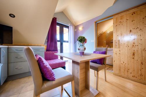 a dining room with a table and purple chairs at Apartments Villa Anka in Komiža