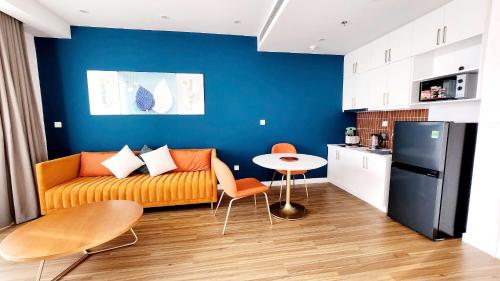 フーコックにあるAura Aparmentのソファとテーブルとキッチンのあるリビングルーム