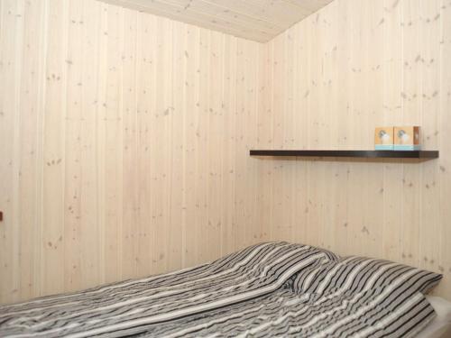 a bed in a room with a wooden wall at Seaside Escape in Ho Bay - By Traum Ferienwohnungen in Ho