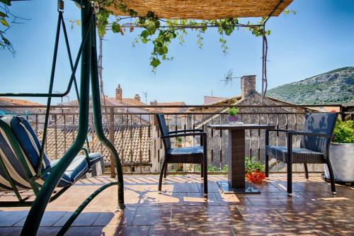 a patio with chairs and a table with a view at Apartments Villa Anka in Komiža