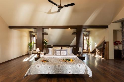 a bedroom with a large bed with a ceiling fan at Nirvana Luxurious Pool Garden Villa in Vasai in Vasai