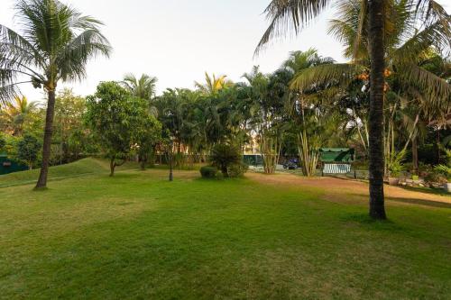 a park with palm trees and green grass at Nirvana Luxurious Pool Garden Villa in Vasai in Vasai