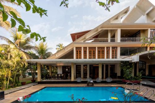 an exterior view of a house with a swimming pool at Nirvana Luxurious Pool Garden Villa in Vasai in Vasai