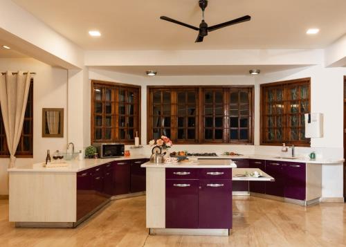 a kitchen with purple cabinets and a ceiling fan at Nirvana Luxurious Pool Garden Villa in Vasai in Vasai