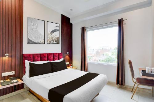 a bedroom with a large bed and a window at Super Townhouse Oak Arvindo Park Indira Nagar Formerly Rama Inn in Vibhuti Khand