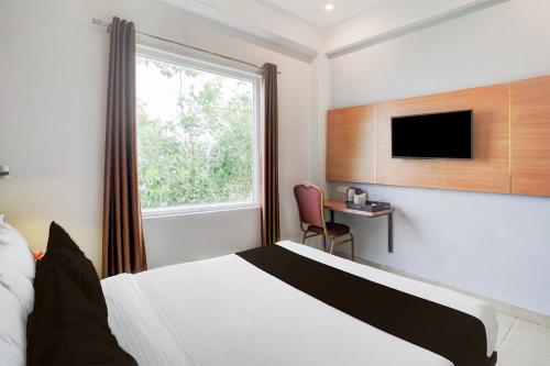 a hotel room with a bed and a window at Super Townhouse Oak Arvindo Park Indira Nagar Formerly Rama Inn in Vibhuti Khand