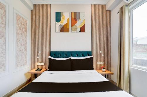 a bedroom with a large bed and two tables at Super Townhouse Oak Arvindo Park Indira Nagar Formerly Rama Inn in Vibhuti Khand