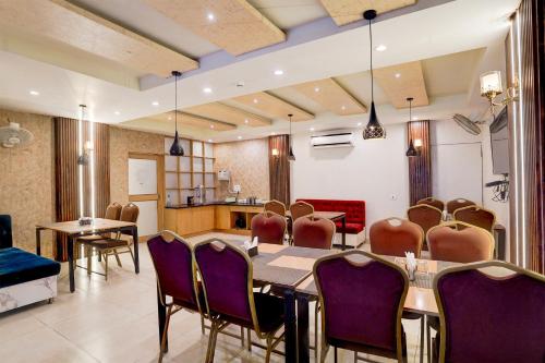 a dining room with a table and purple chairs at Super Townhouse Oak Arvindo Park Indira Nagar Formerly Rama Inn in Vibhuti Khand