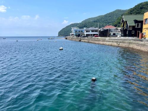 a large body of water with buildings and houses at TAKUMI-AN Private Ancient House and Garden in Numazu