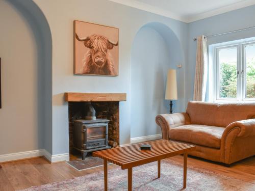 a living room with a couch and a fireplace at Lanes Farm in Eakring