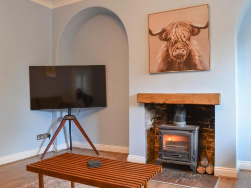 a living room with a fireplace with a cow on the wall at Lanes Farm in Eakring
