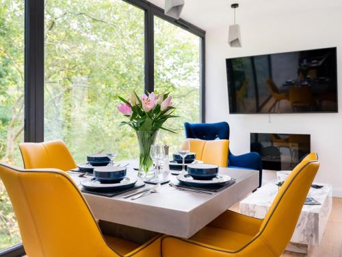 a dining room with a table and yellow chairs at The Keep in Hebden Bridge