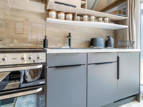 a kitchen with white cabinets and an oven at Aqueduct Hideaway in Llangollen