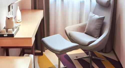 a room with a chair and a table and a desk at Lavande Hotel Changchun Gaoxin Jilin University in Changchun