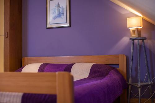 a bedroom with a bed with purple sheets and a lamp at Apartments Villa Anka in Komiža