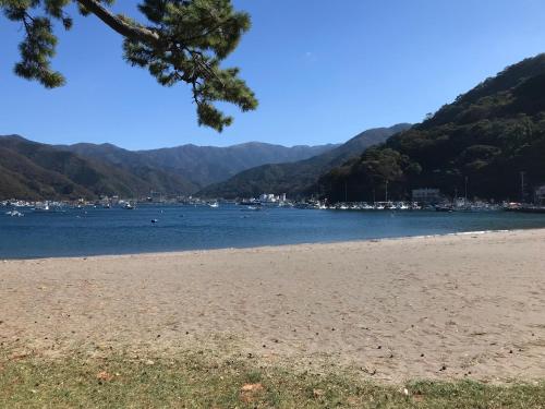a view of a beach with mountains in the background at TAKUMI-AN Private Ancient House and Garden in Numazu
