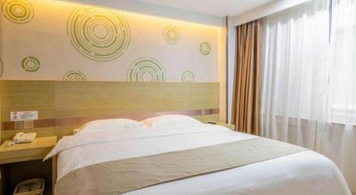 Ένα ή περισσότερα κρεβάτια σε δωμάτιο στο GreenTree Inn High-tech Zone Shandong University Bathing Beach Hotel