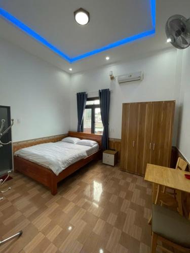 a bedroom with a bed with a blue ceiling at Nhà Nghỉ Hoàng Giang in Tiên Hai
