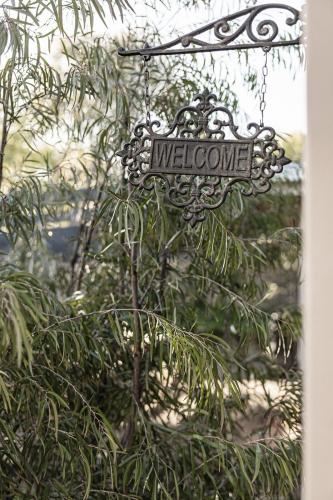 a welcome sign hanging from a tree at The Willows Coastal Retreat in Old Ocean Grove in Ocean Grove