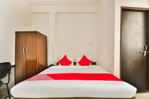 a bedroom with a large bed with red pillows at Hotel O Q7 in Kota