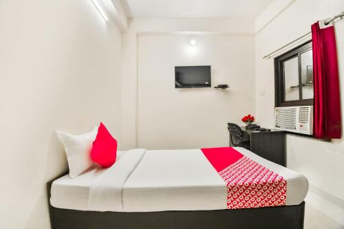 a small bedroom with a bed and a television at Hotel O Q7 in Kota
