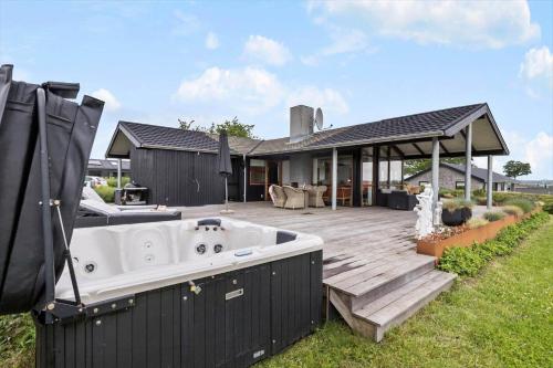a bath tub sitting on a deck next to a house at 84164-Ronde-Stenhojvej-17 in Rønde