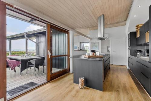 a kitchen with a table and a dining room at 84164-Ronde-Stenhojvej-17 in Rønde