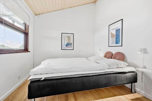 a bedroom with a large bed in a room with a window at 84164-Ronde-Stenhojvej-17 in Rønde