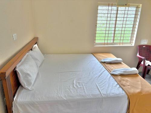a bedroom with a bed with a wooden headboard and a window at Deeksha homestay in Hampi