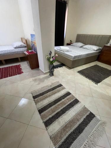 a bedroom with two beds and two rugs on the floor at Domus Komanesse - Guest Houses in Koman