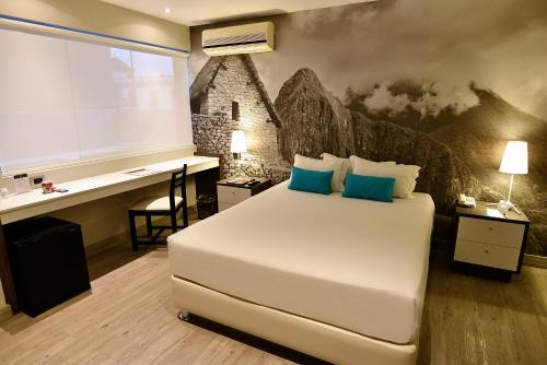 een slaapkamer met een wit bed, een bureau en een muur bij Mariel Hotel Boutique in Lima