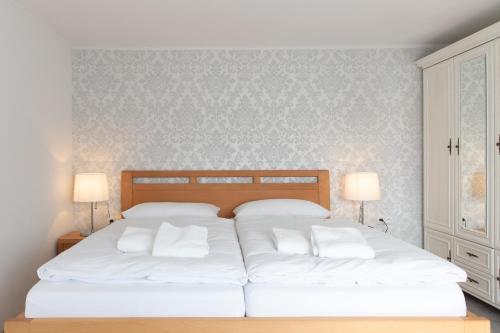a bedroom with a large bed with two white pillows at Ubytování Na Zámecké in Milotice