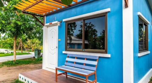 a blue house with a blue bench on a deck at BanRai ChernMa Resort in Tak