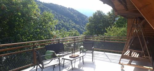 a balcony with two chairs and a table with a view at Casa Zaharia Azuga in Azuga