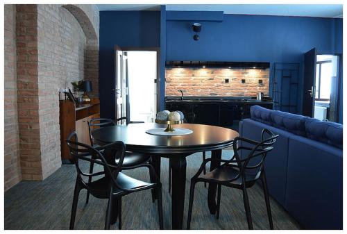 a dining room with a table and chairs and a couch at Apartamenty Róże i Zen in Toruń